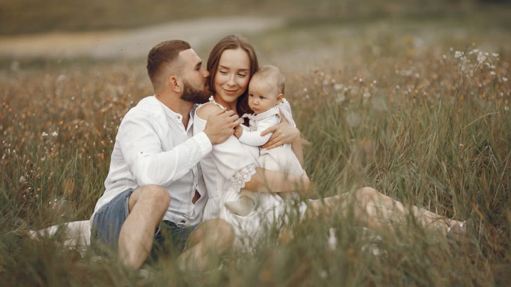 Happy family enjoying quality time in a serene meadow setting.